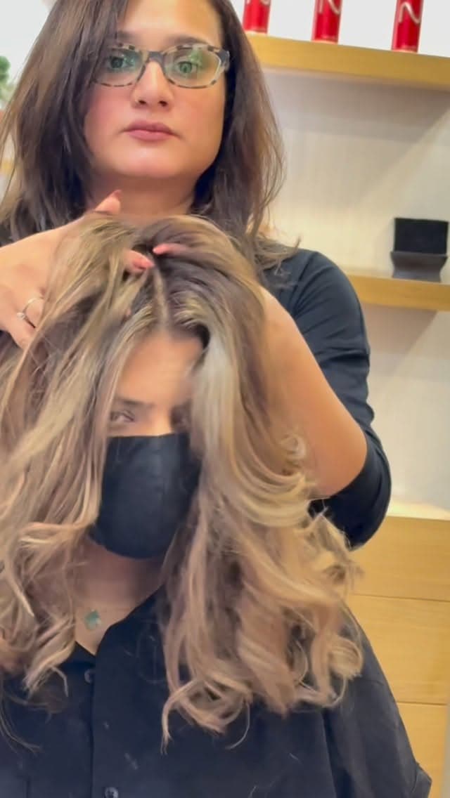 Stylist finishing voluminous waves in the lounge