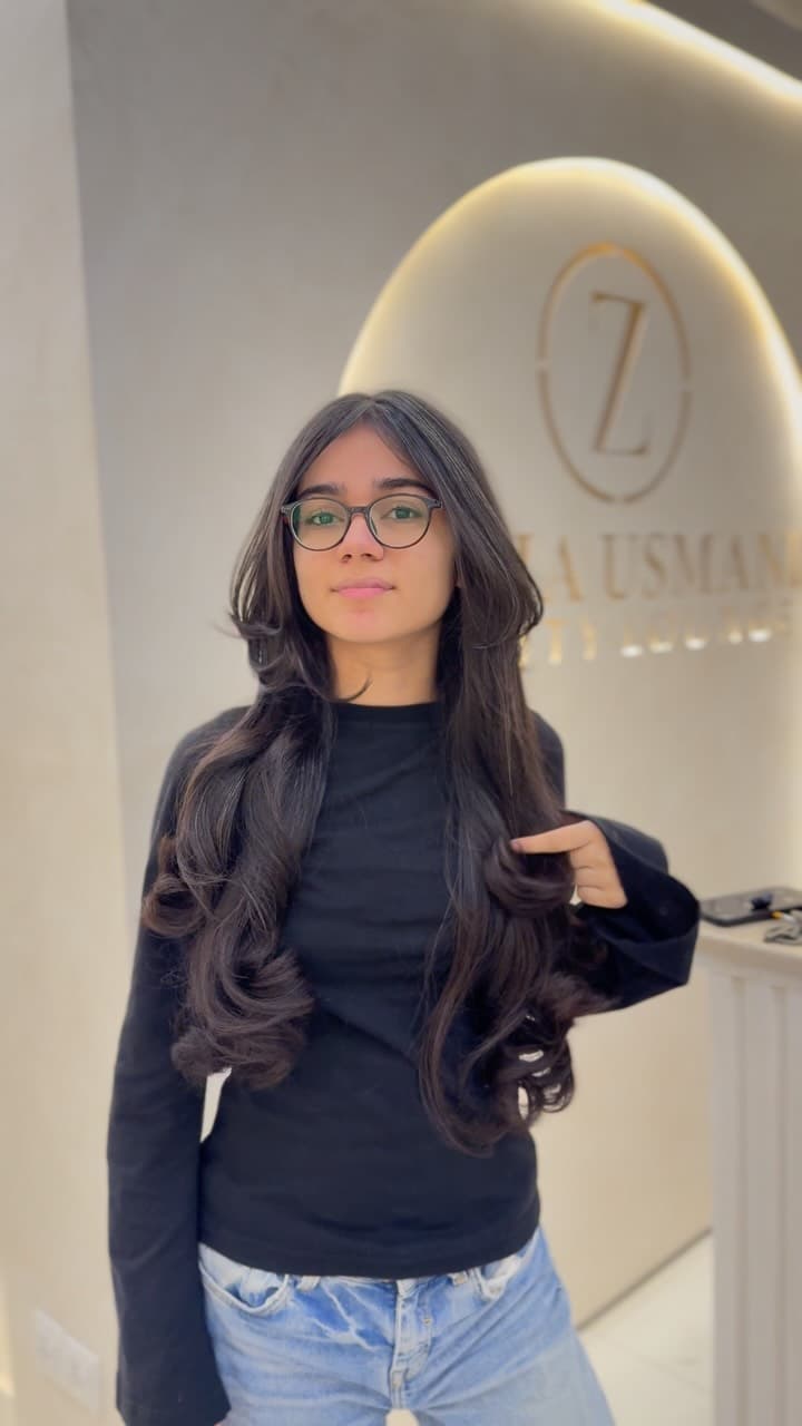 Client styled under the Zuvia Usmani Beauty Lounge gold emblem